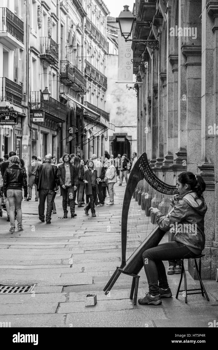 Street musician playing harp dans une rue de Santiago de Compostela. Banque D'Images