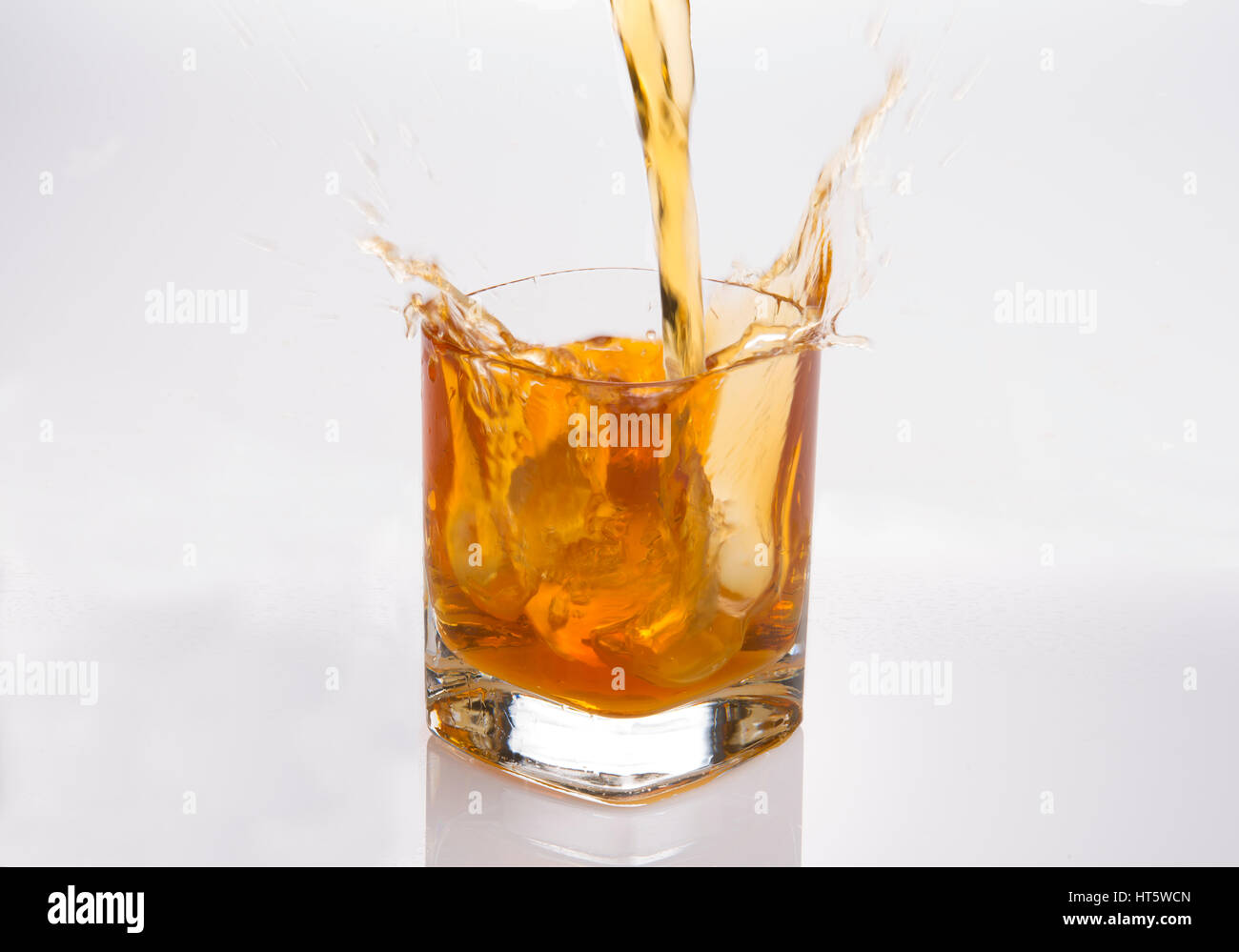 Splash en verre de whisky écossais avec des cubes de glace Banque D'Images