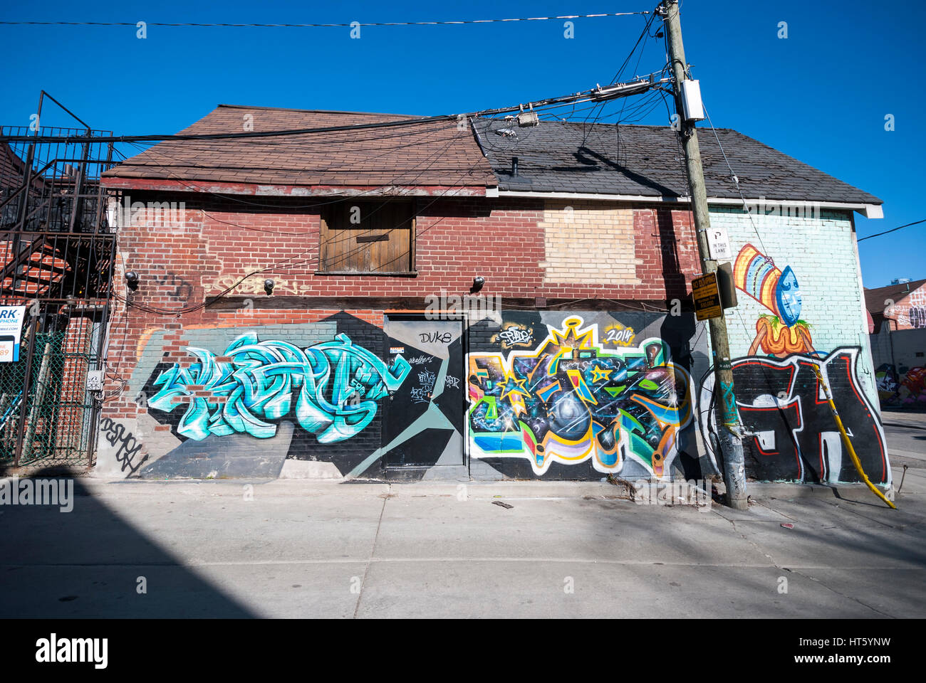 Un mur couvert de graffitis et porte sur un immeuble dans une ruelle de Kensington Market, à Toronto (Ontario) Canada. Banque D'Images