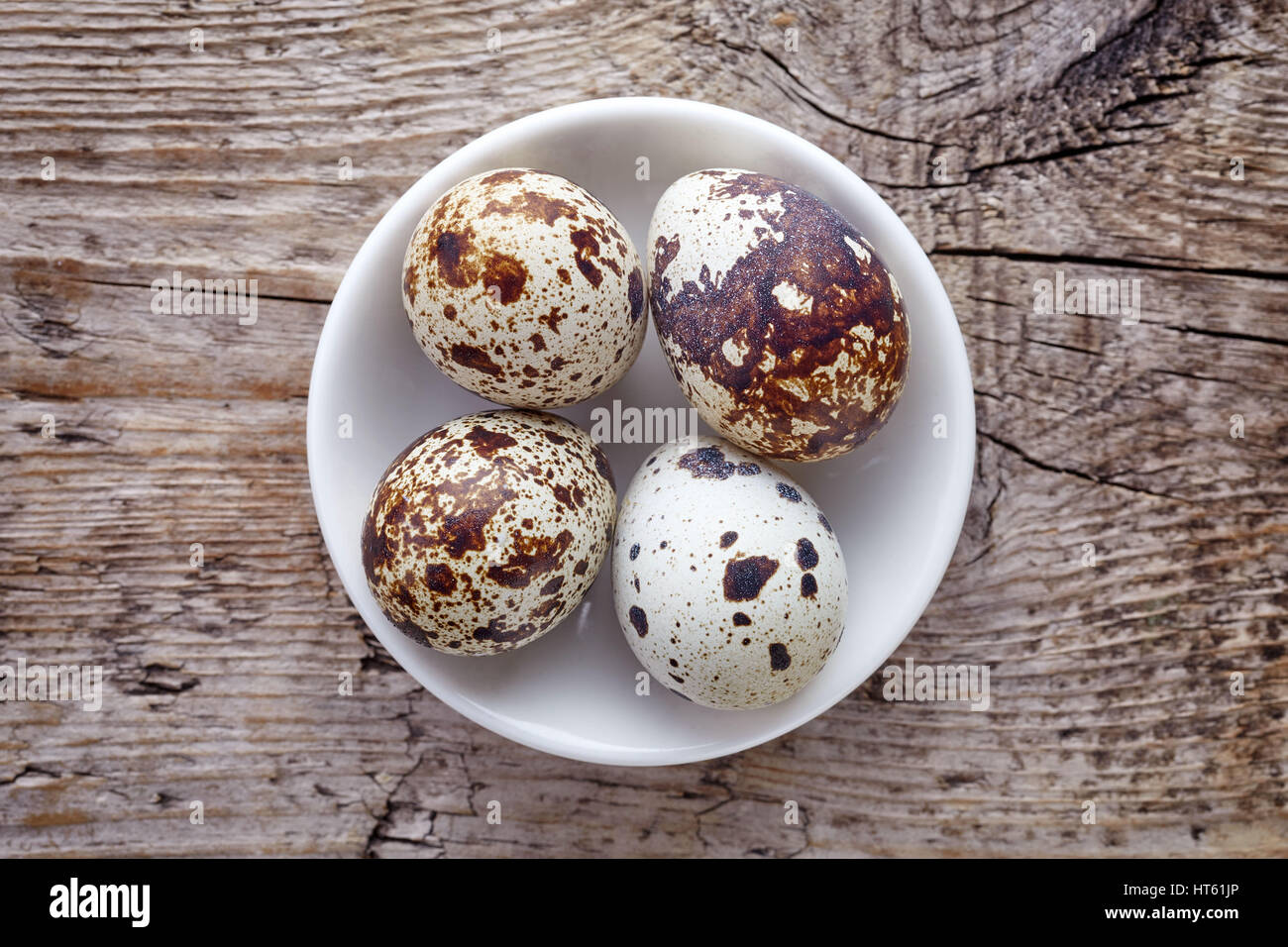 Bol d'oeufs de cailles sur fond de bois, vue du dessus Banque D'Images