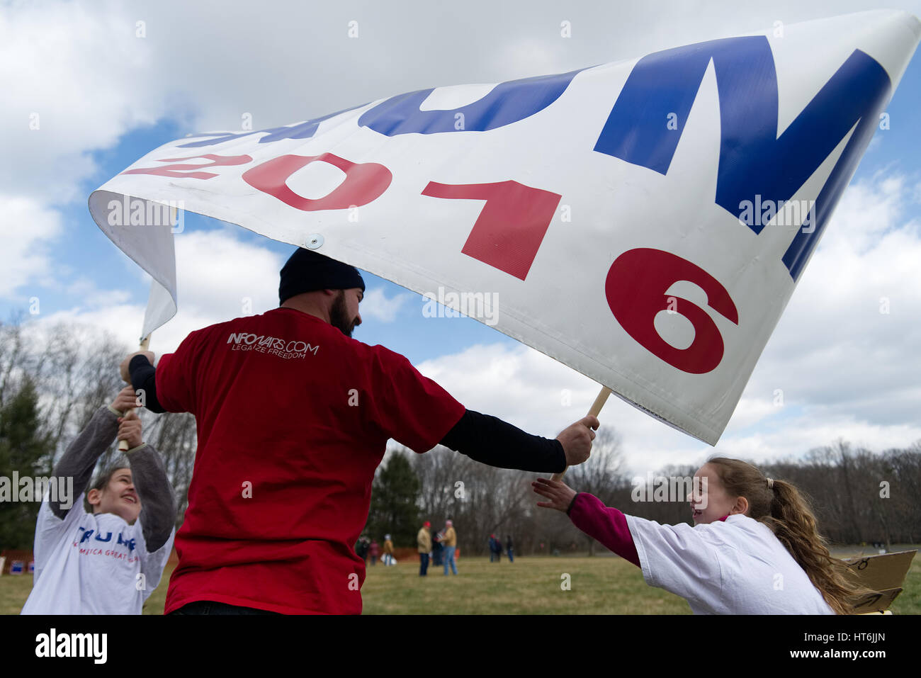 Kaylee et Eva comme Pigiannantonio aide Pete, au nord-est de Philadelphie, lutte avec le vent comme ils se déroulent un grand TRUMP 2016 banner, en prévision d'un pro Banque D'Images