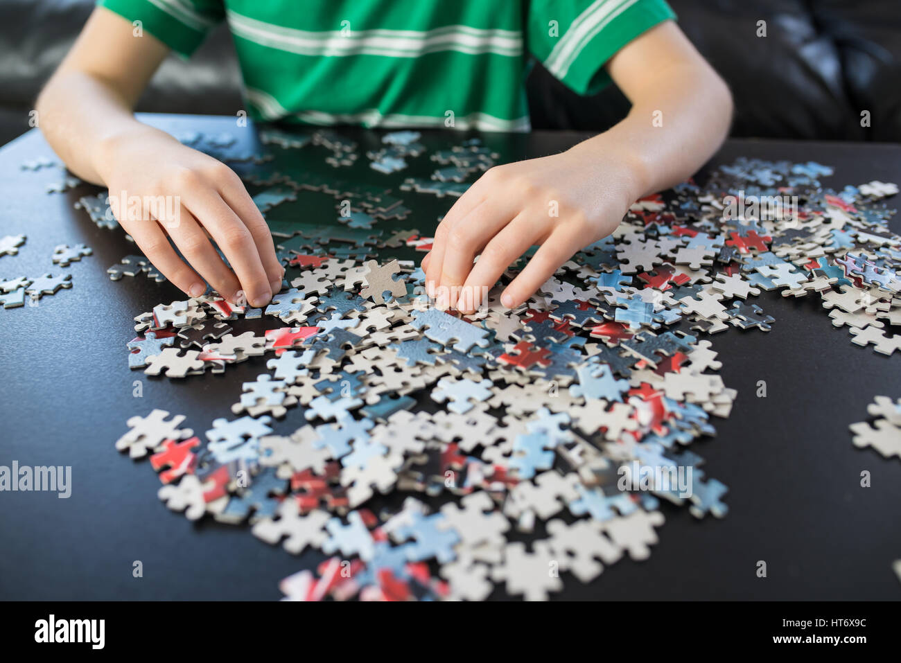 Mains d'un enfant de faire un puzzle à table Photo Stock - Alamy