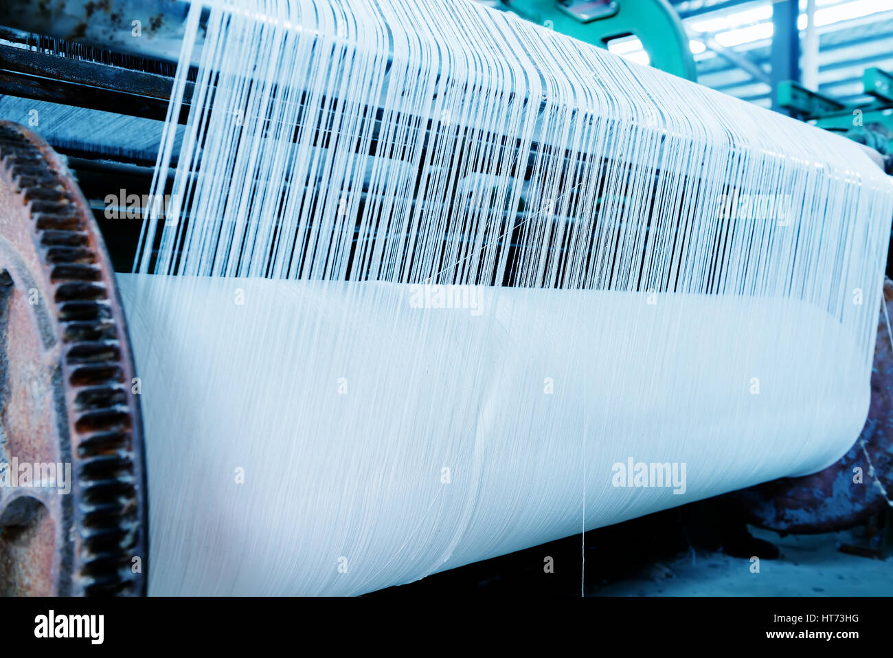 Une rangée de métiers textiles tissage de fils de coton dans une usine de textile Banque D'Images