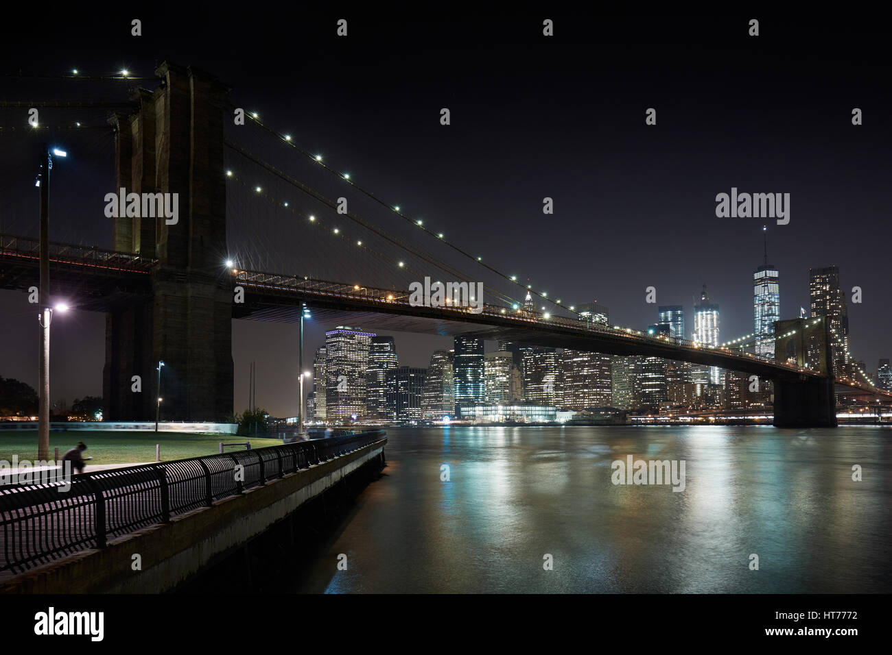 Pont de Brooklyn et New York city skyline illuminée la nuit avec docks Banque D'Images