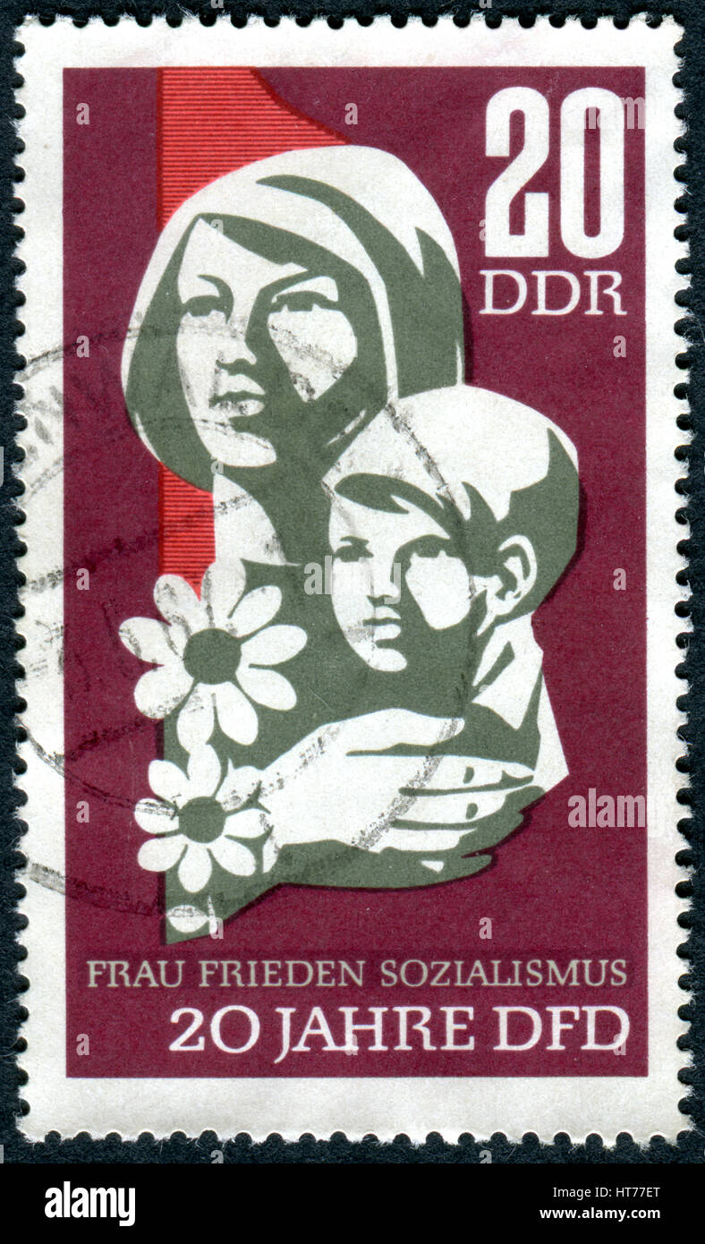 Un timbre imprimé en Allemagne (RDA), dédié à la 20e anniversaire de Fédération des femmes démocratiques de l'Allemagne, montre la femme avec enfant Banque D'Images