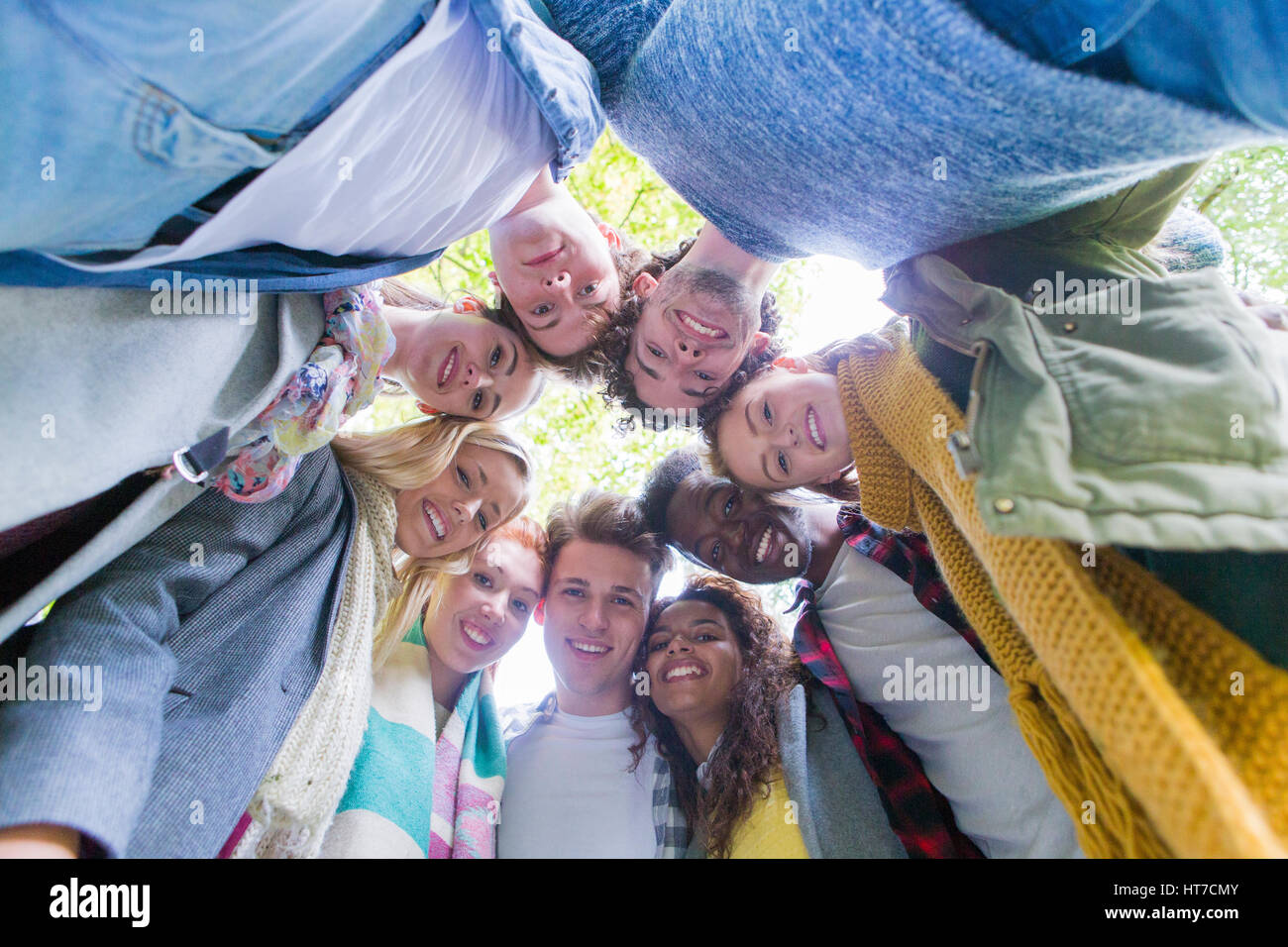 Un groupe d'étudiants adolescents heureux sourire alors qu'ils donnent à l'appareil photo. Ils sont debout dans un cercle avec la tête ensemble. Banque D'Images