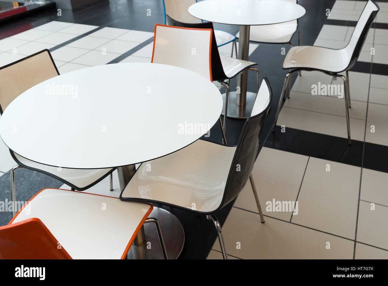 Tables et chaises en plastique blanc dans un café Banque D'Images