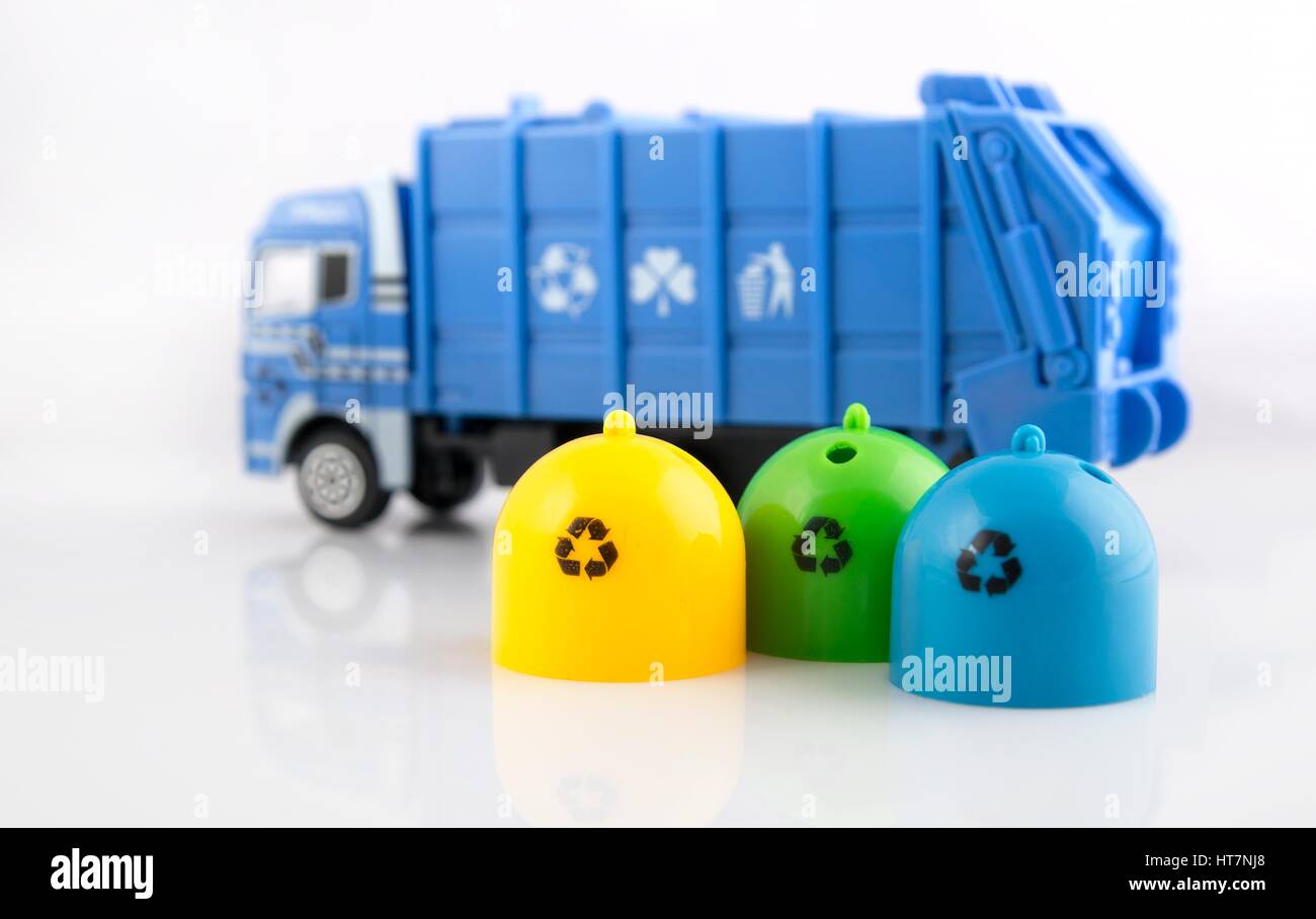 Poubelles couleur camion poubelle et jouets sur fond blanc Banque D'Images
