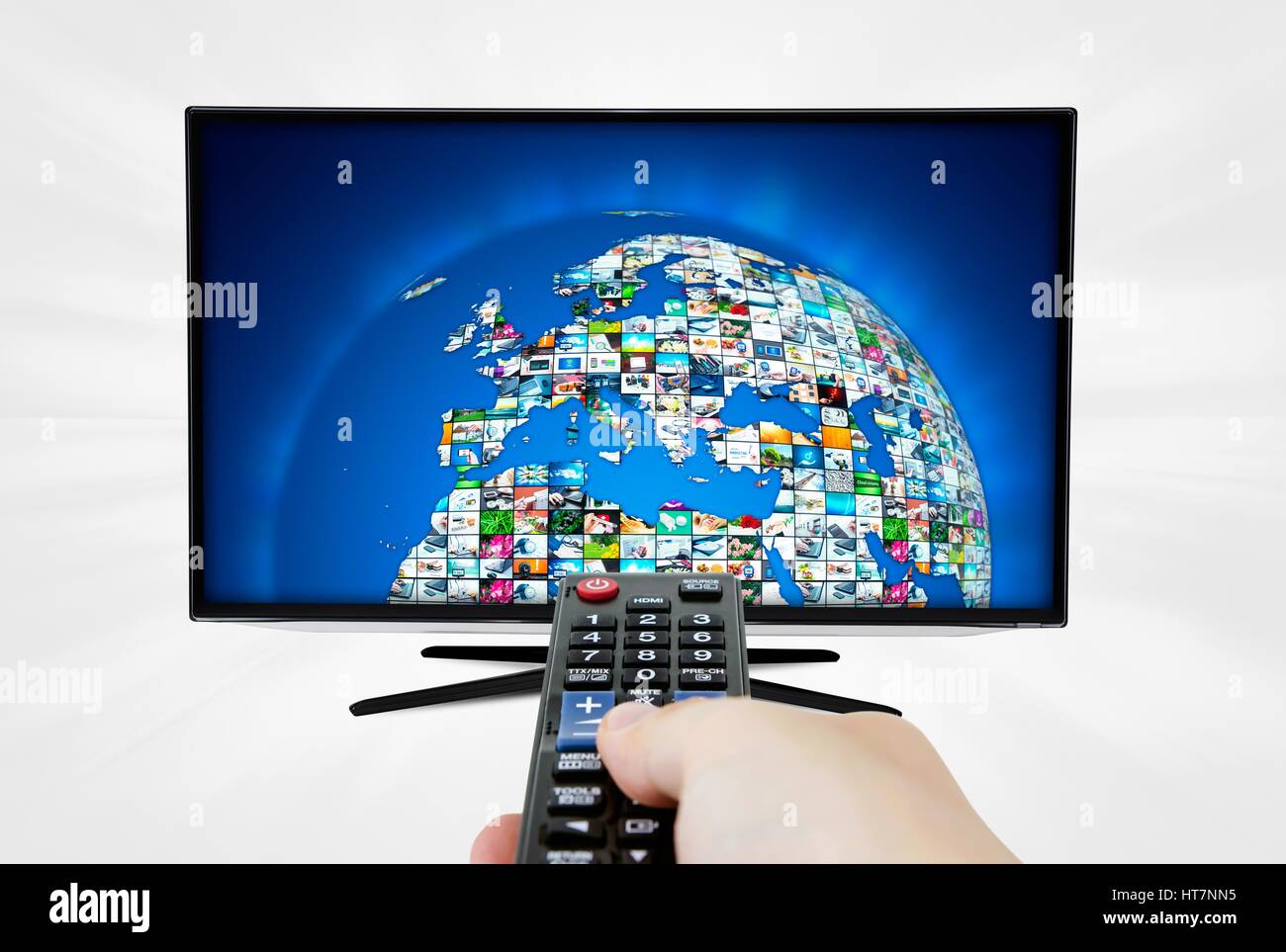 La télévision haute définition à écran large écran avec sphere galerie de vidéos. Télécommande en main Banque D'Images
