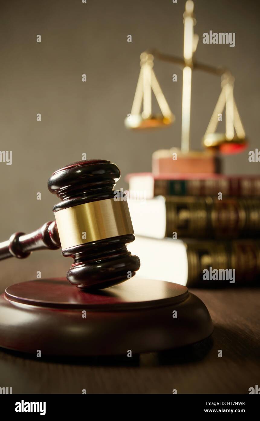 Wooden gavel et des livres sur la table en bois. Livres sur l'échelle en arrière-plan. Banque D'Images