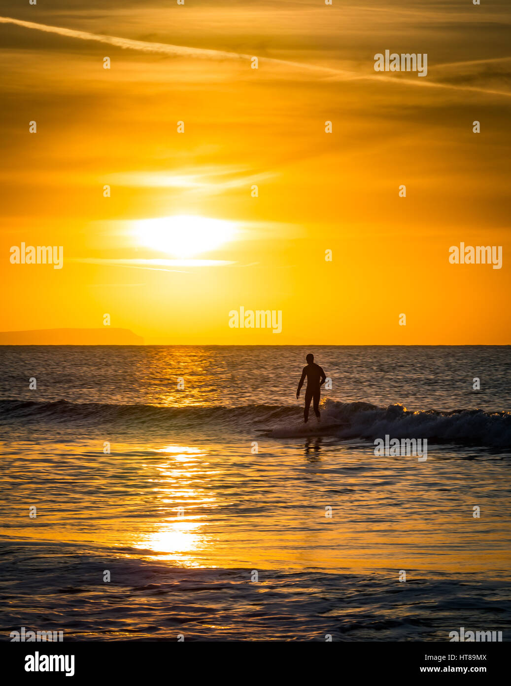 Un surfeur au lever du soleil sur la plage de Bournemouth Banque D'Images