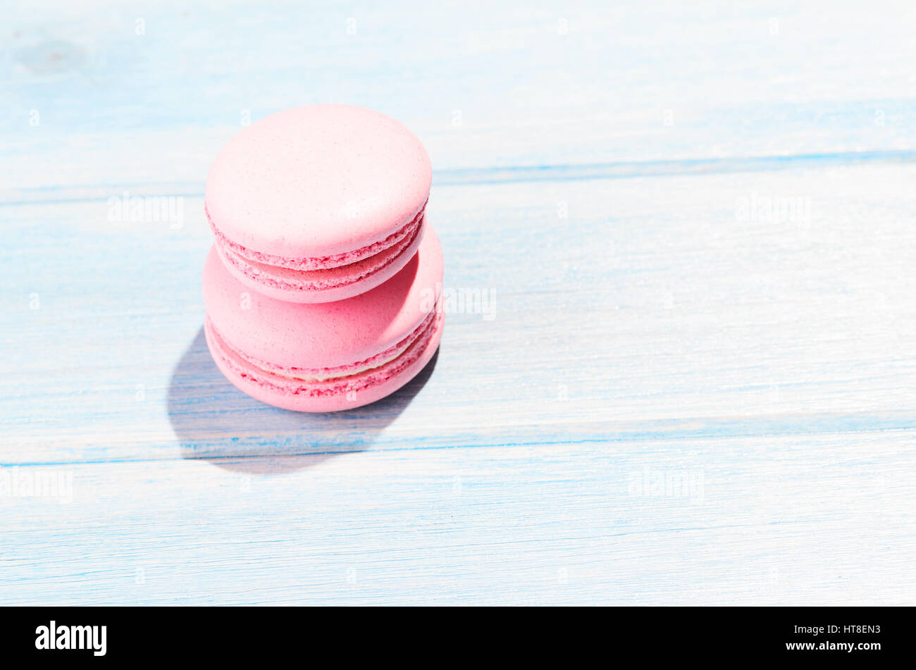 Deux macarons rose sur table en bois bleu Banque D'Images