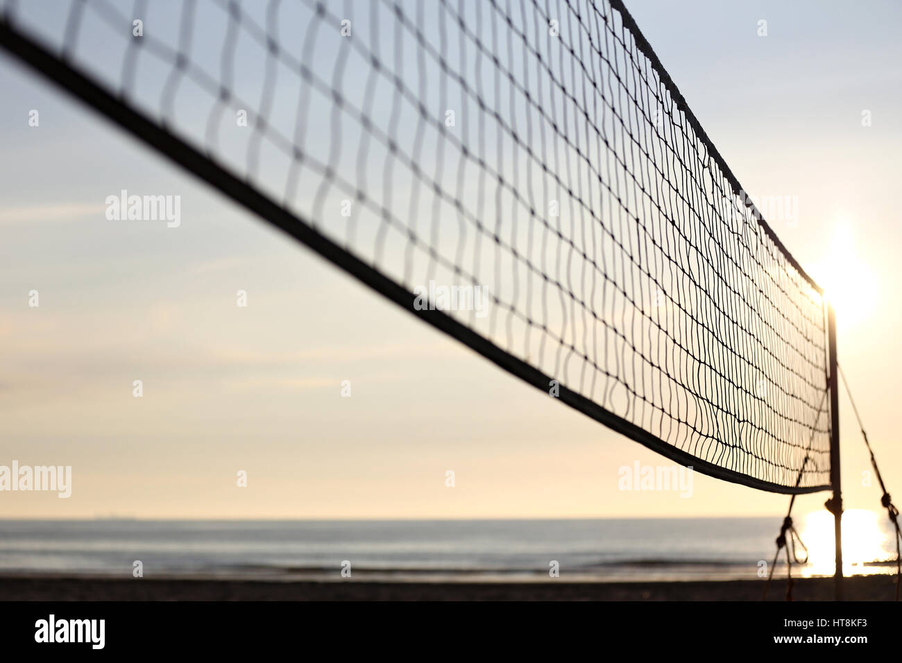 Cour de sable de volley-ball de plage au coucher du soleil Banque D'Images