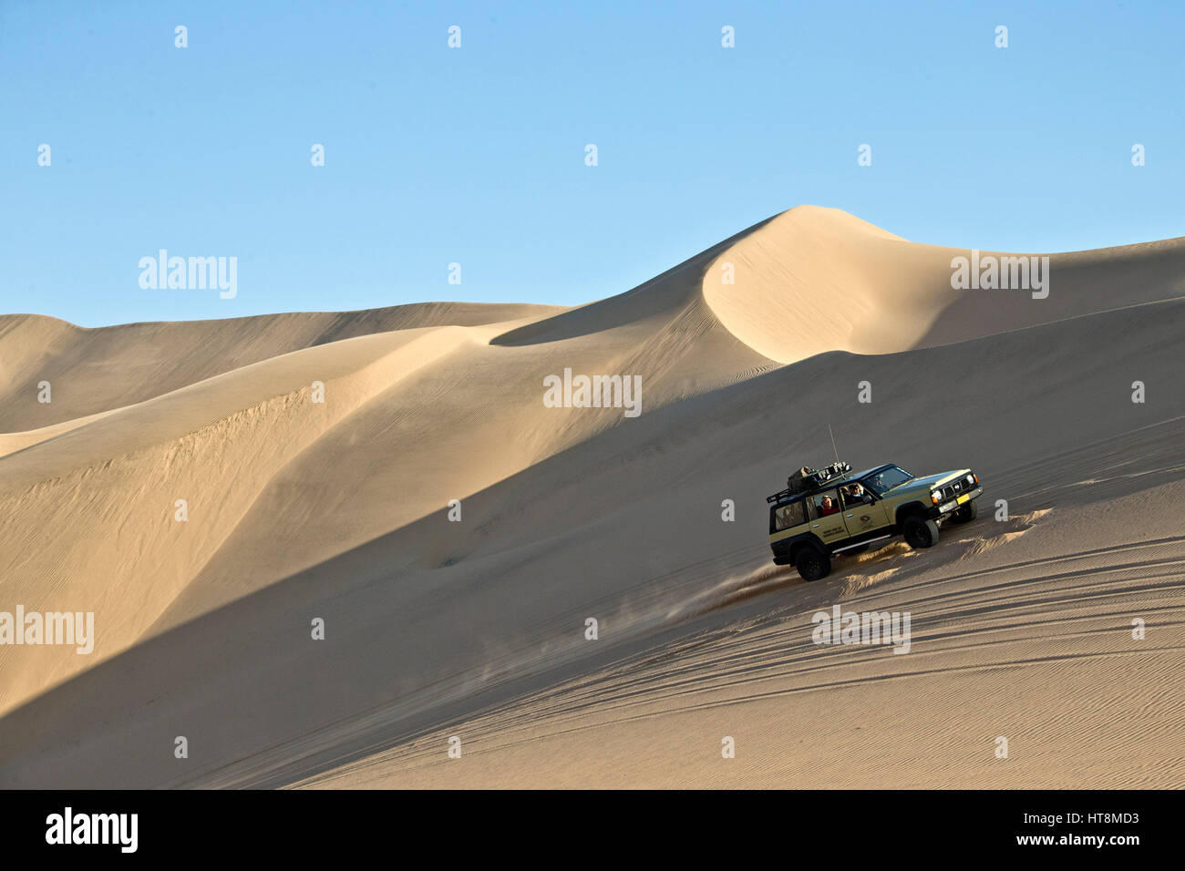 Un véhicule La route jusqu'à la face raide d'un côté de la mer de dunes en Namibie Banque D'Images