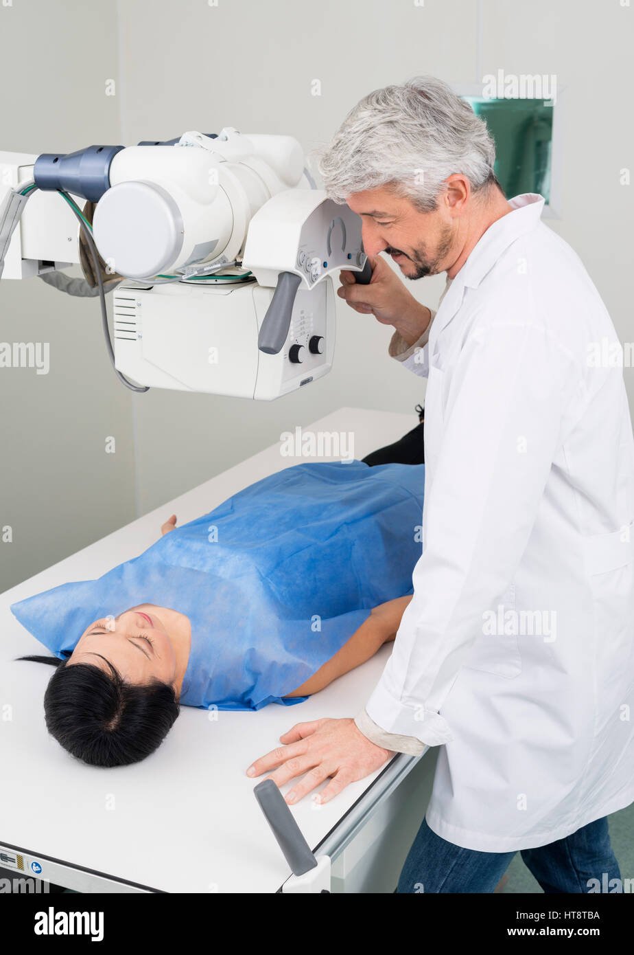 Mâle mature radiologue réglage de machine à rayons x sur la femme patient in hospital Banque D'Images