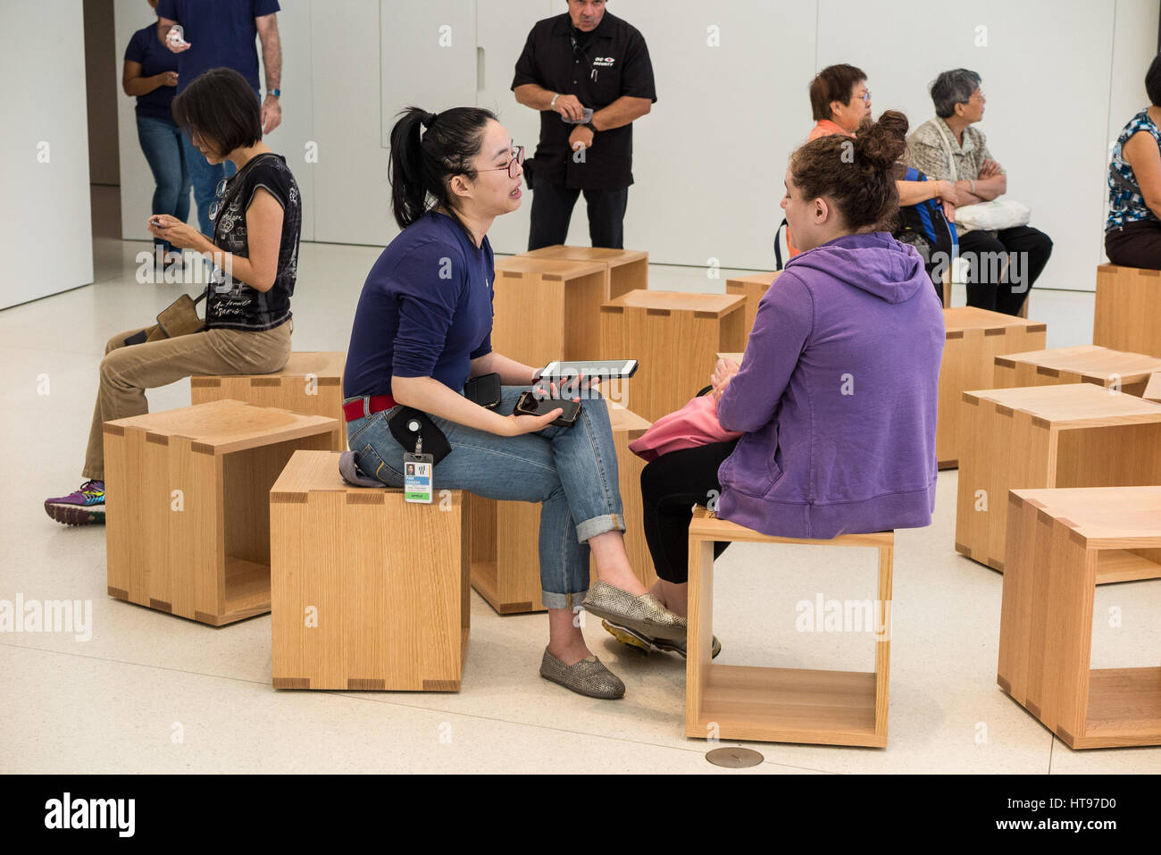 Employé de l'Apple Store pendant son une aide avec un client à l'intérieur de l'Apple Store Banque D'Images