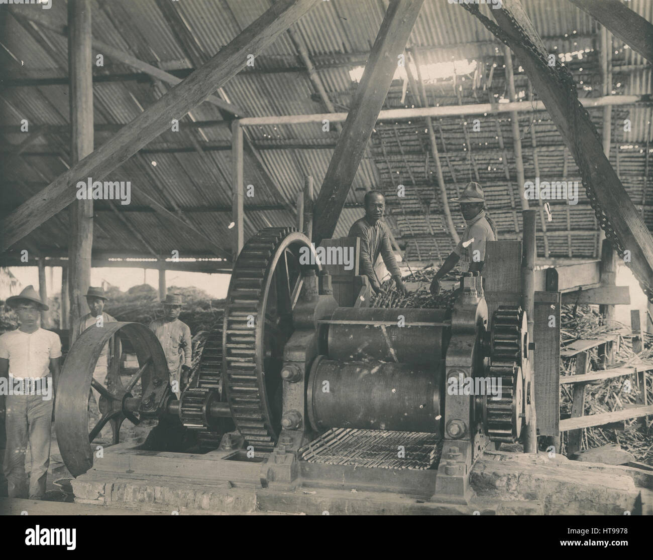 Les anciens industriels 1915 photo d'un moulin à canne à sucre et de machines les travailleurs de l'île de Panay, Philippines. Avis les grandes vitesses (CMV, rouages, engrenages) d'une presse et d'un grand volant. Source : photo découvert aux États-Unis. Banque D'Images
