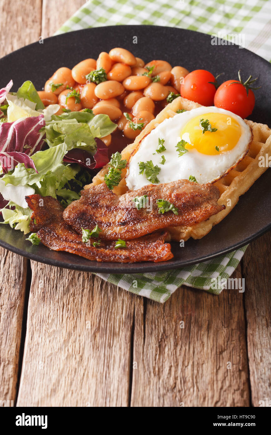 Petit-déjeuner sain : sandwich waffle avec œufs, bacon, haricots et de la salade sur une assiette. La verticale Banque D'Images