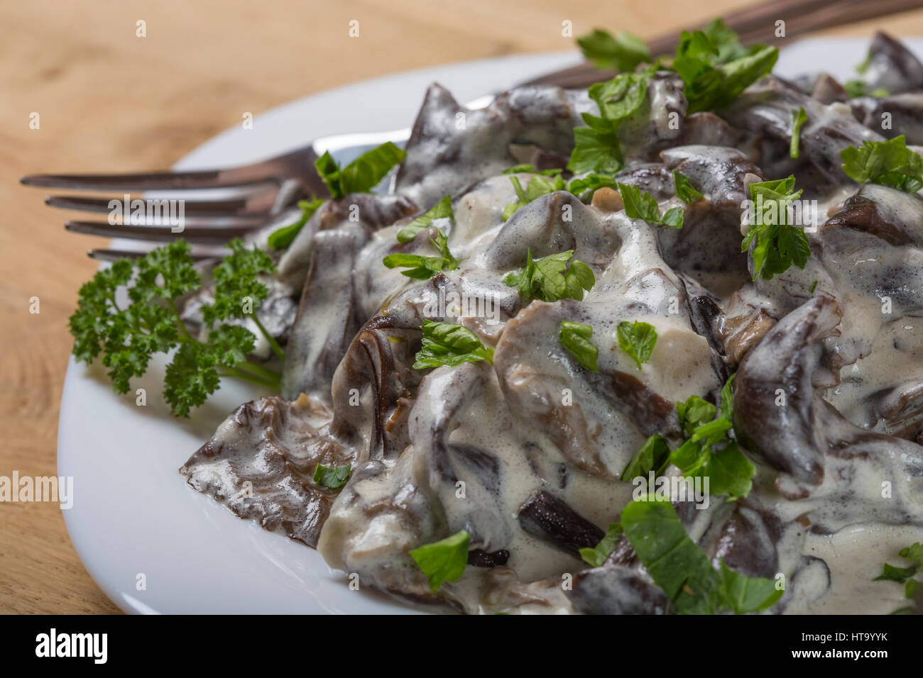 Alimentaire roumain - champignons à la crème et le persil dans une assiette avec une fourchette Banque D'Images