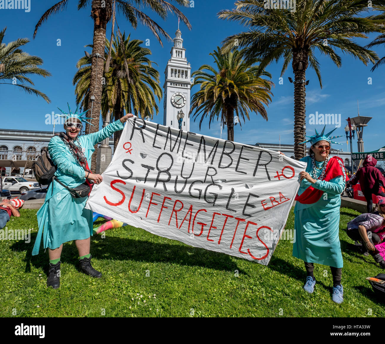 San Francisco, USA. Mar 8, 2017. Deux femmes habillées comme la Statue de  la liberté drapés dans les chaînes et ceintures rouges posent avec leur  signe, 