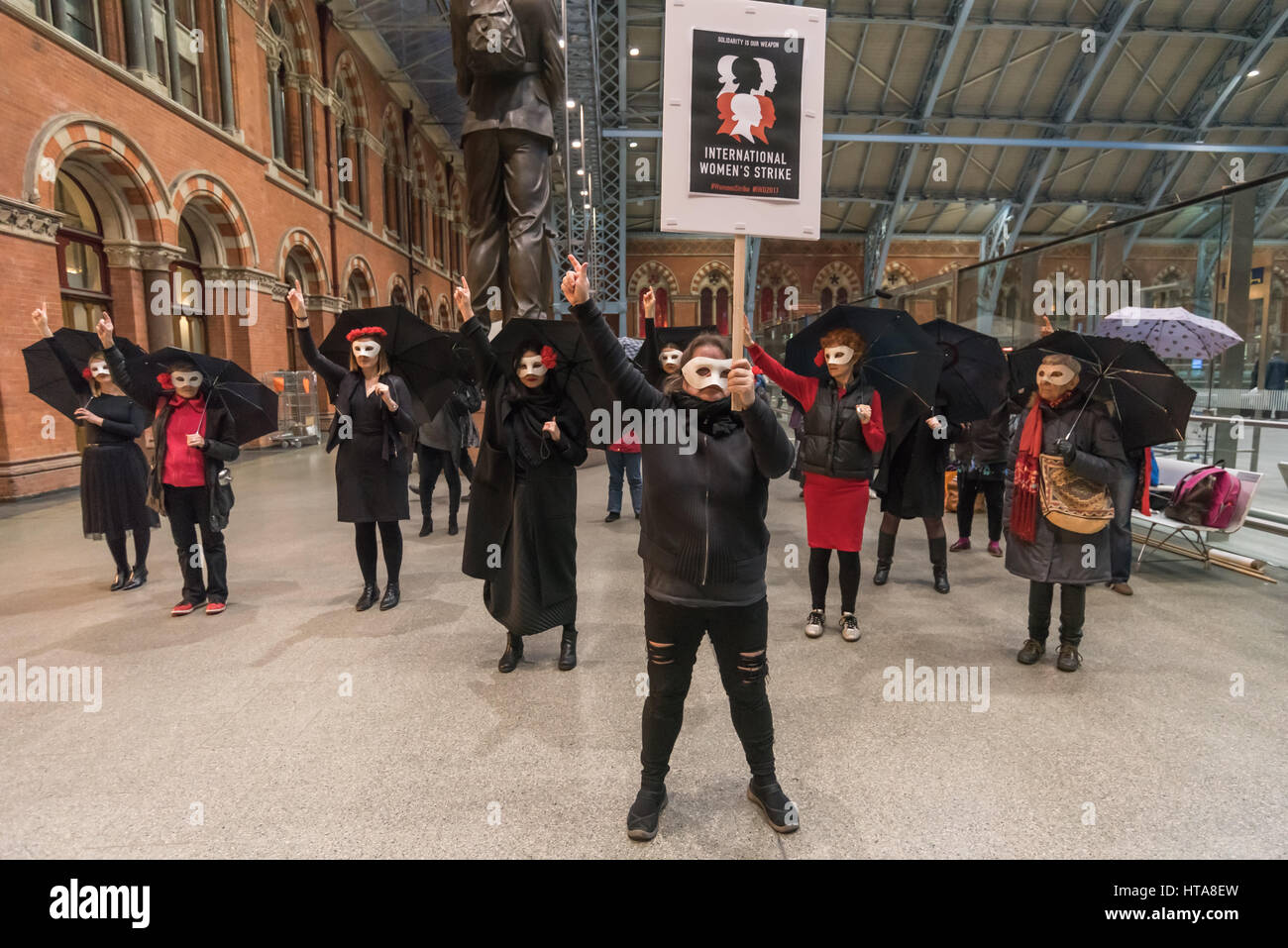 Londres, Royaume-Uni. 8 mars 2017. Les féministes polonais de Londres ont été rejoints par Grève mondiale des femmes en solidarité avec les femmes dans 46 pays prenant part à l'International la grève des femmes lors de la Journée internationale des femmes célébrant les luttes des femmes dans le monde entier dans un flash mob à St Pancras International. Porter des vêtements noirs et rouges, après avoir pratiqué leur routine de parapluies avec messages sur eux et une grande banderole à l'entrée de St Pancras International ils descendirent vers le hall principal de l'accomplir. Crédit : Peter Marshall/Alamy Live News Banque D'Images