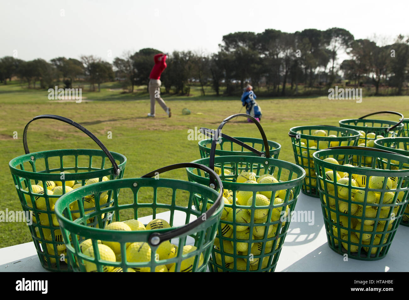 Les golfeurs sur le champ de pratique à l'aube Banque D'Images