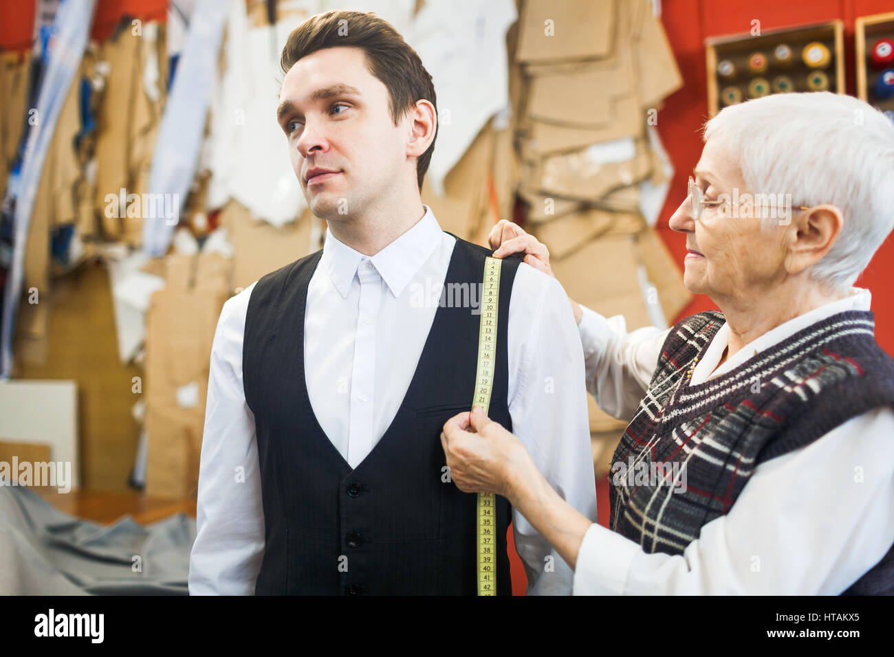 Les jeunes client en chemise et gilet visiter atelier de couture Banque D'Images