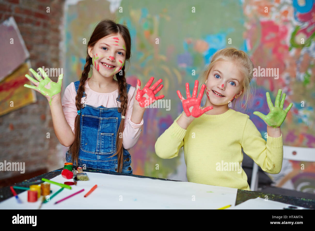 Deux funny girls, avec de la verdure et de la peinture rouge sur palms Banque D'Images