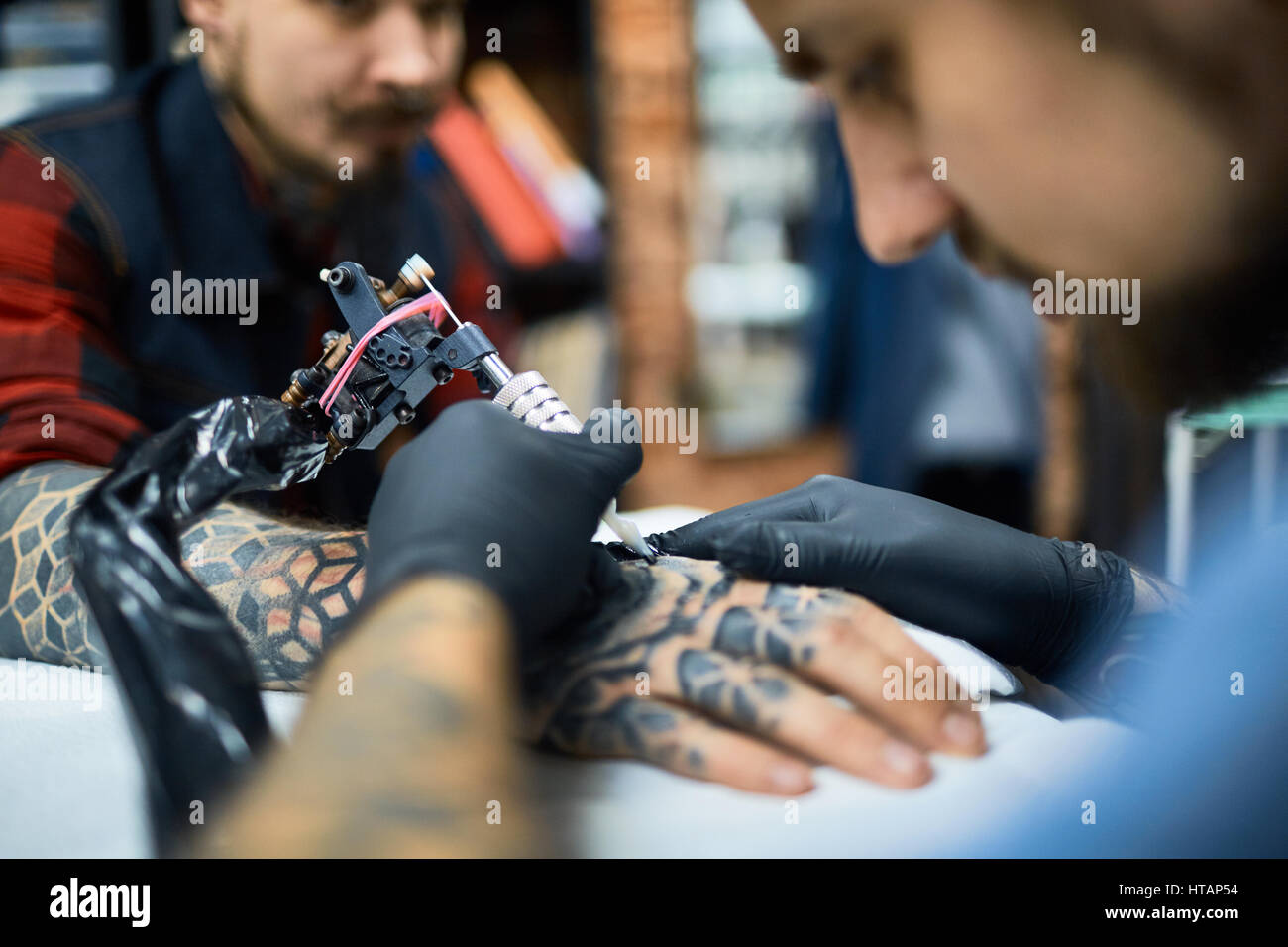 Maîtresse de dessin tatouage au bras du jeune homme Banque D'Images