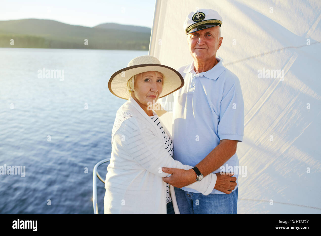 Senior couple looking at camera tout en voyageant par bateau Banque D'Images