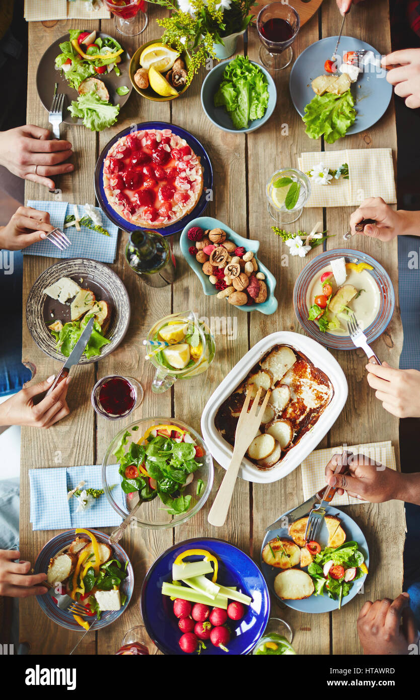 Mains d'amis de manger la nourriture végétarienne par le dîner Banque D'Images