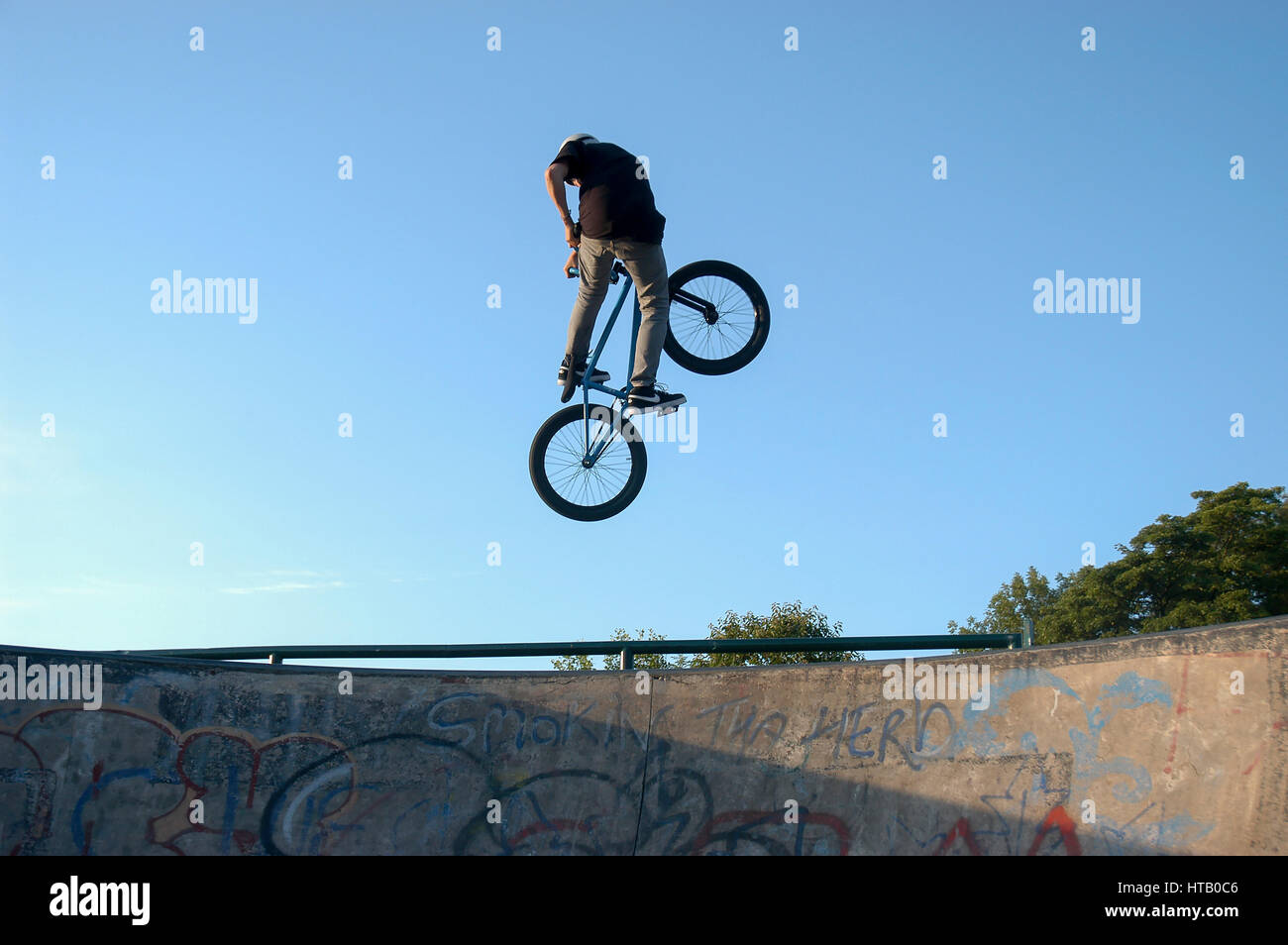 Biker BMX haut géant contre un ciel bleu Stock