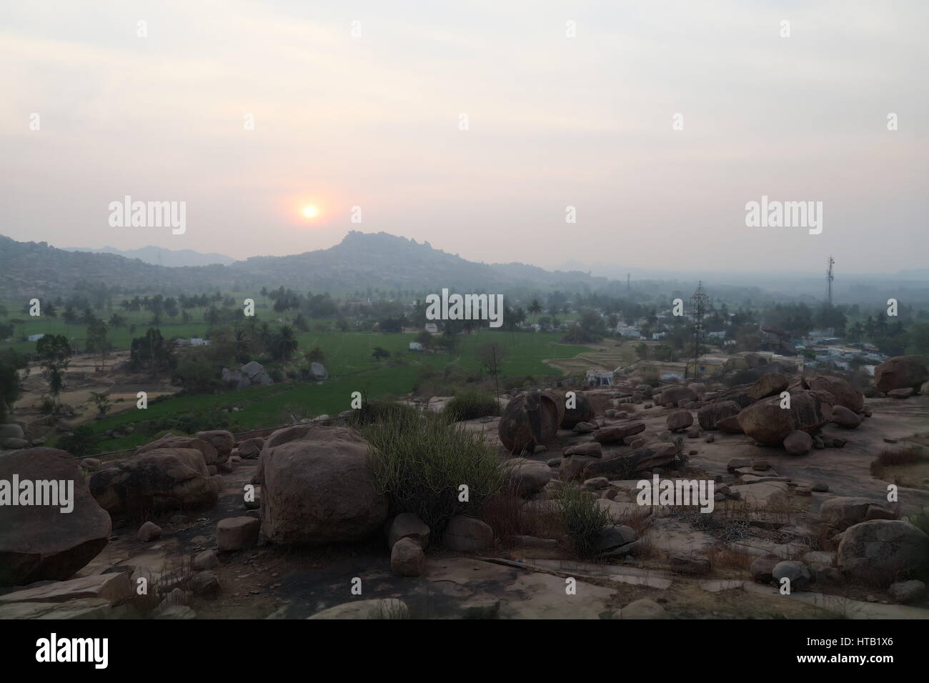 Coucher de soleil avec une large vue sur des champs verdoyants et un paysage de rochers unique à Hampi, Karnataka, Inde, un site du patrimoine mondial de l'UNESCO, très mystique. Banque D'Images