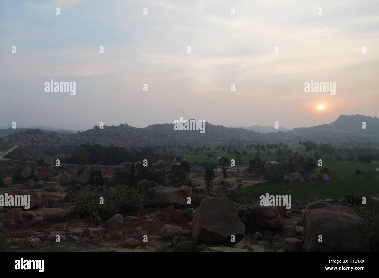 Coucher de soleil avec une large vue sur des champs verdoyants et un paysage de rochers unique à Hampi, Karnataka, Inde, un site du patrimoine mondial de l'UNESCO, très mystique. Banque D'Images