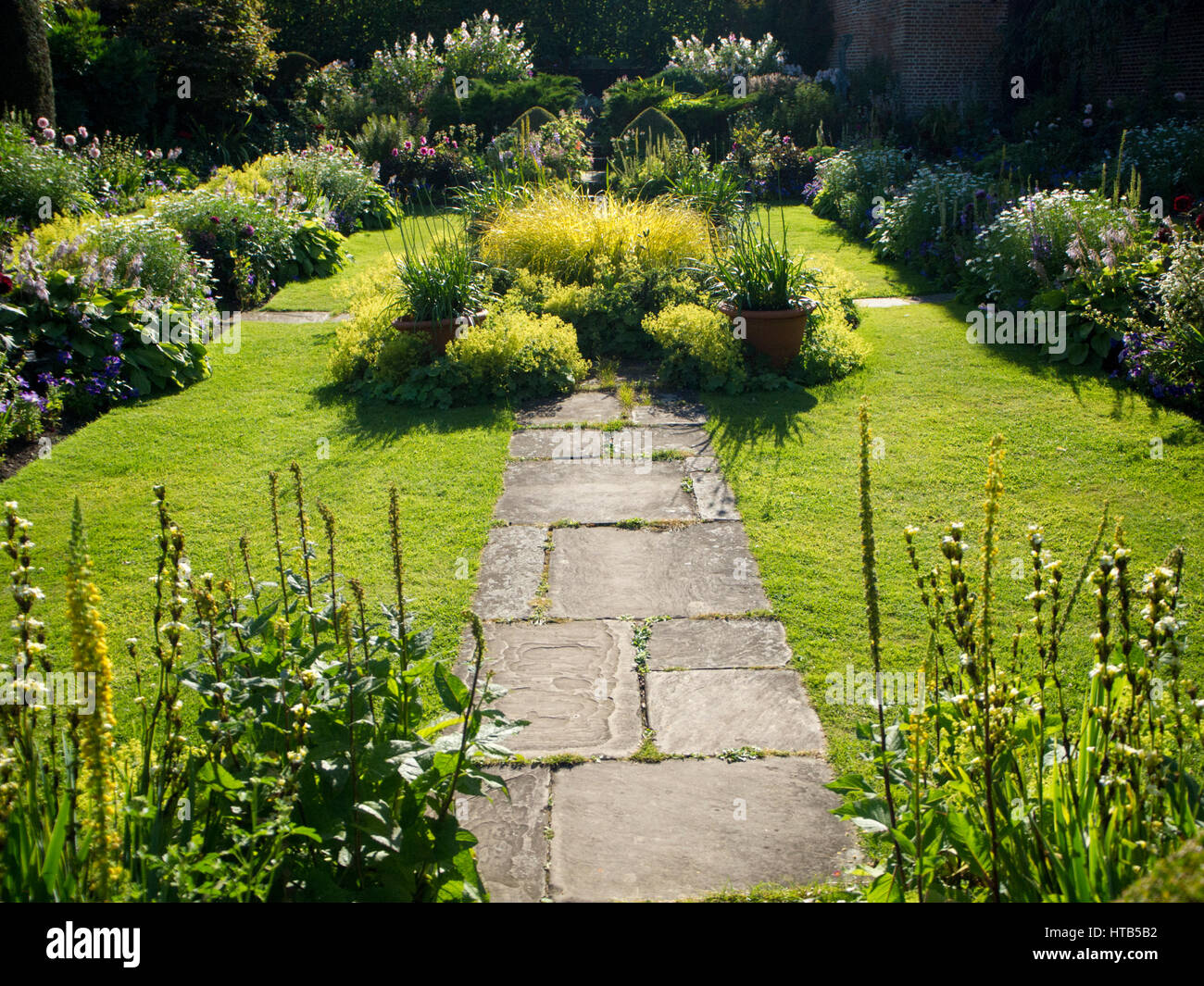 Chenies Manor Jardin En Contrebas En Fin D Apres Midi Avec La Lumiere Du Soleil Et D Ombre Autour De L Etang Ornemental Encadree Par Les Plantes Et Fleurs De La Frontiere De Hauteur Photo Stock