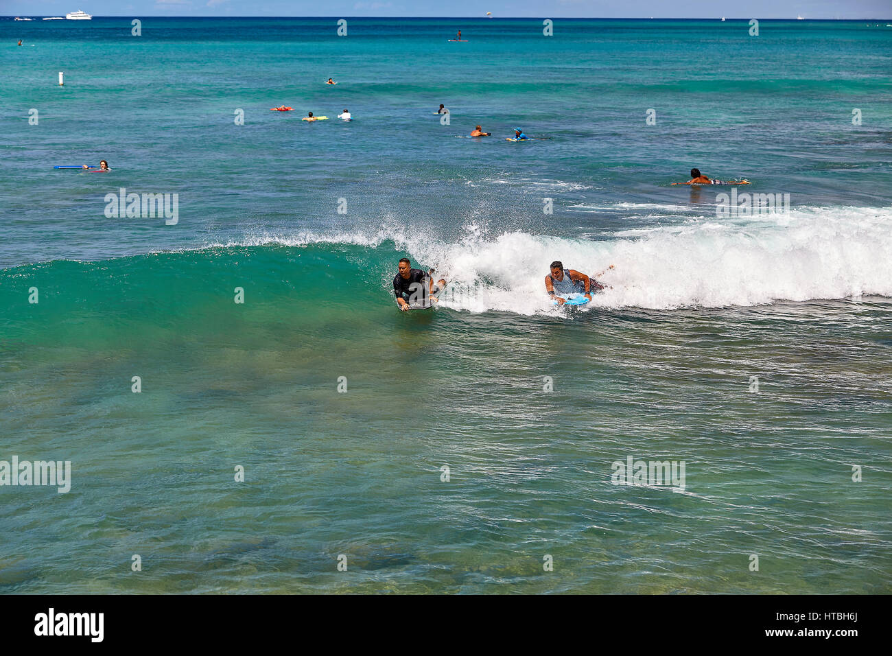 La plage de Waikiki, Hawaii, USA -- 2 Août 2016 : Unidentified boogie board surfeurs attraper une vague de Waikiki Beach Florida Banque D'Images