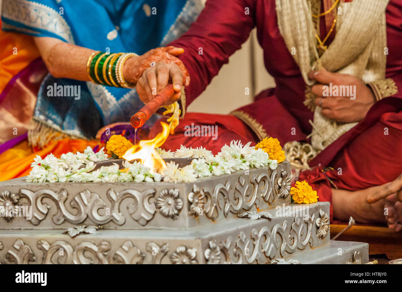 La mariée et le marié à un mariage indien en faisant des offrandes d'huile sur le feu sacré. Banque D'Images