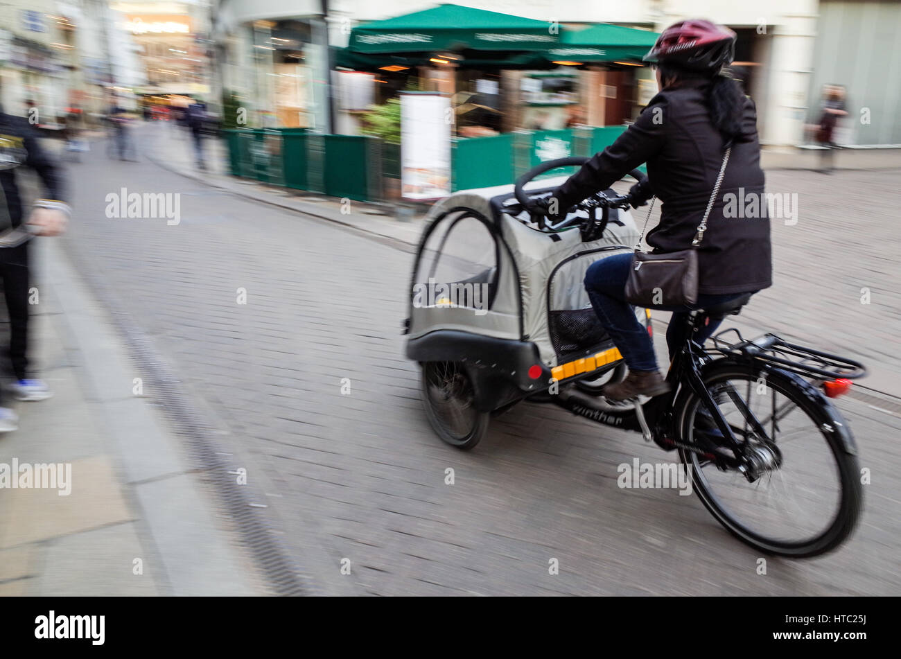 Les parents transportent leurs enfants de l'école dans les vélos-cargos dans le centre de Cambridge Banque D'Images