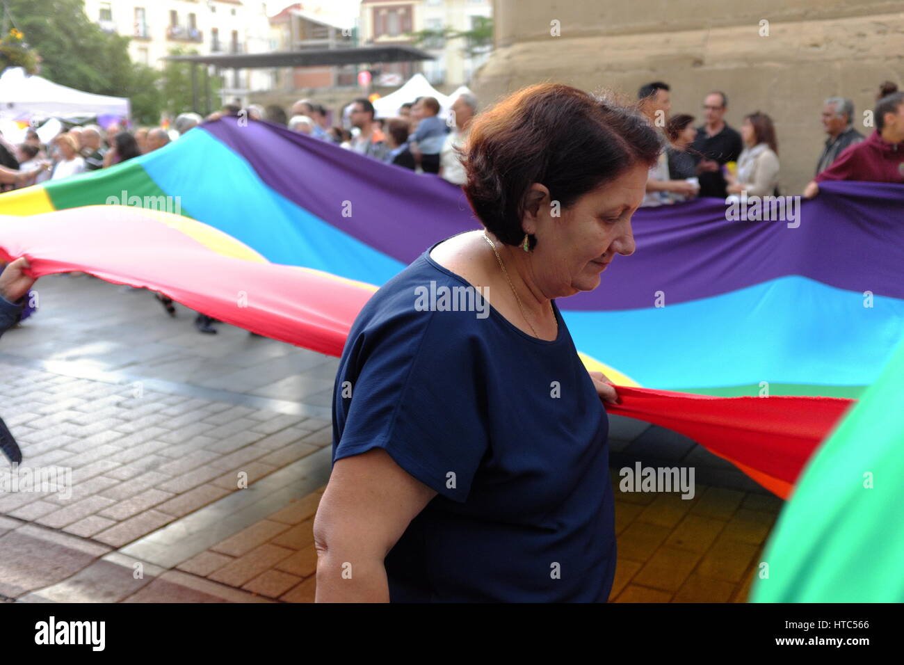 Une femme espagnole aide à porter un drapeau arc-en-ciel à travers la vieille ville de Logrono, Espagne pendant la parade de fierté LGBTQ 2016. Banque D'Images