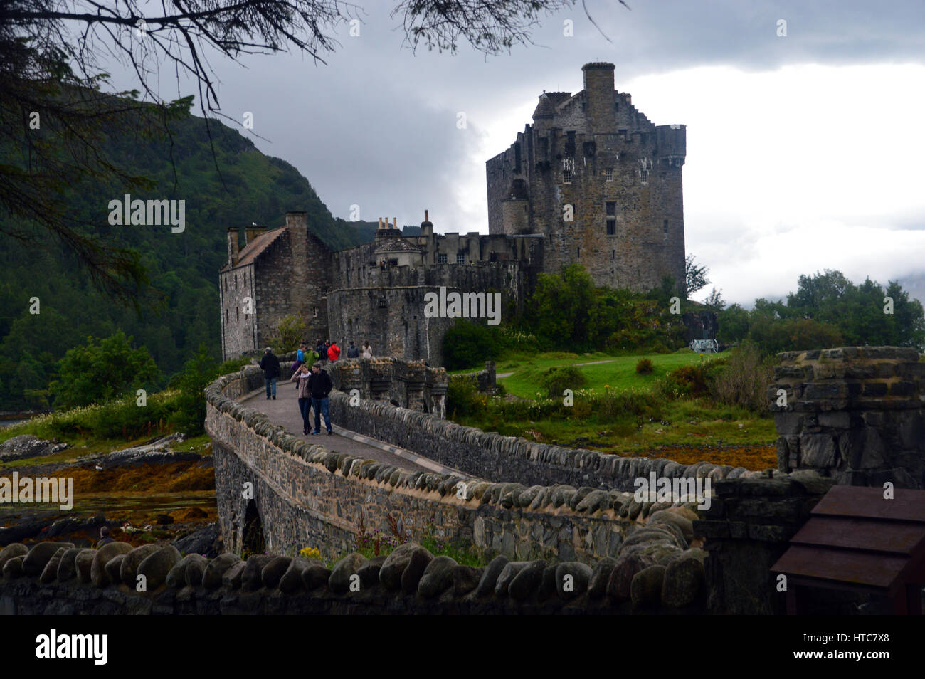 Les touristes marcher sur le pont pour le château d'Eilean Donan en route vers les îles dans les Highlands écossais. Banque D'Images