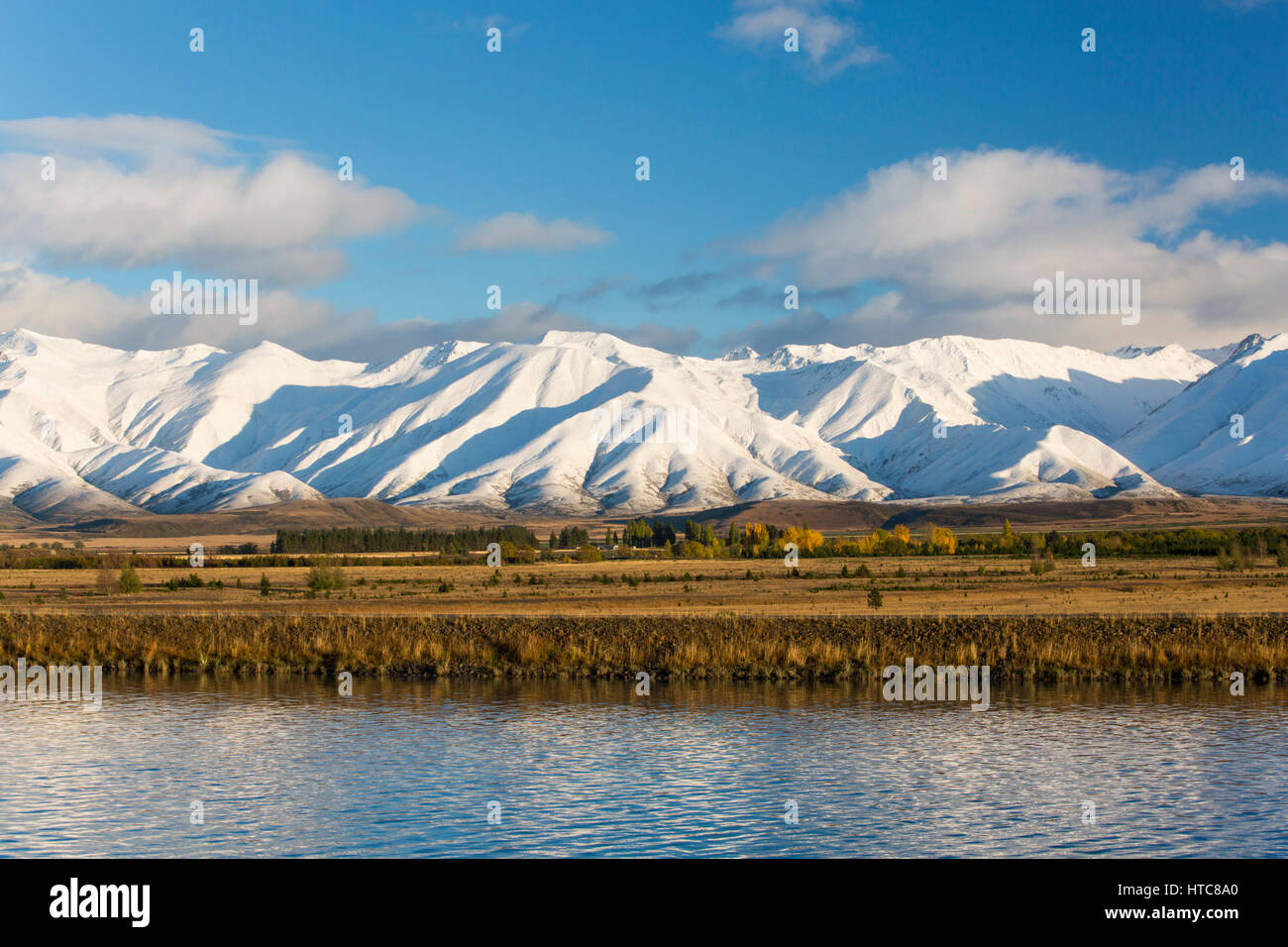 Murchison, Canterbury, Nouvelle-Zélande. La gamme Ben Ohau enveloppé dans la neige de l'automne, début de matinée, le Canal Pukaki en premier plan. Banque D'Images