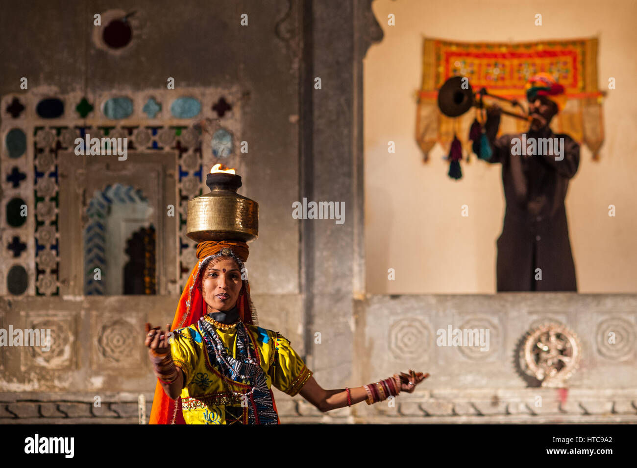 Un trompettiste hérauts un danseur portant un pot de feu sur sa tête au Musée Bagore Ki Haveli soirée à Udaipur Banque D'Images