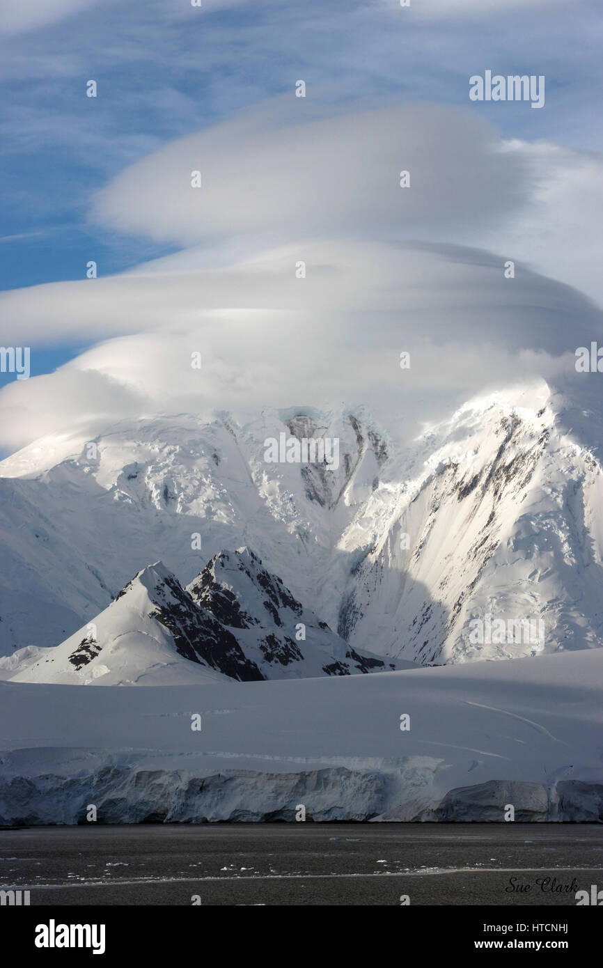 Les rayons du soleil frappent les montagnes neige-couvertes sur la péninsule Antarctique vue de l'expédier sur notre expédition croisière. Banque D'Images