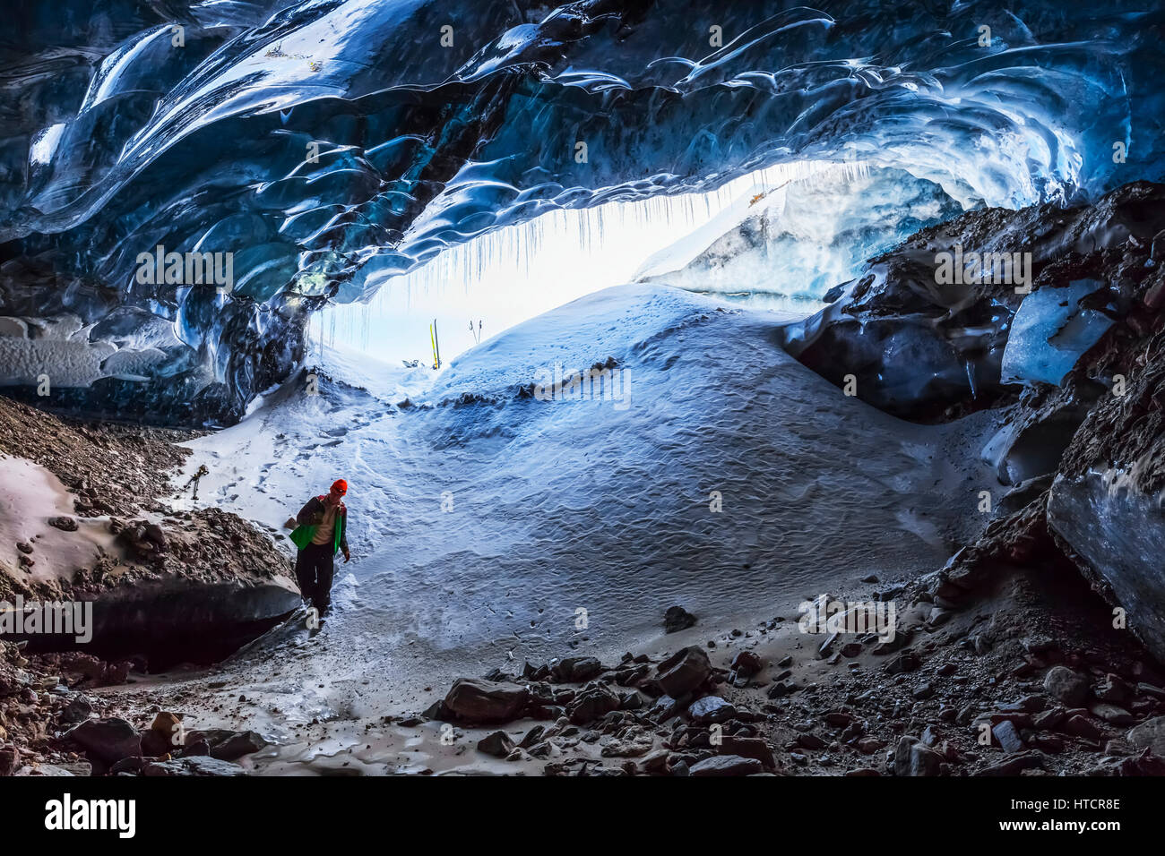 Un homme entre dans une caverne à l'intérieur du Glacier Canwell dans l'Alaska Range en hiver, l'intérieur de l'Alaska, USA Banque D'Images