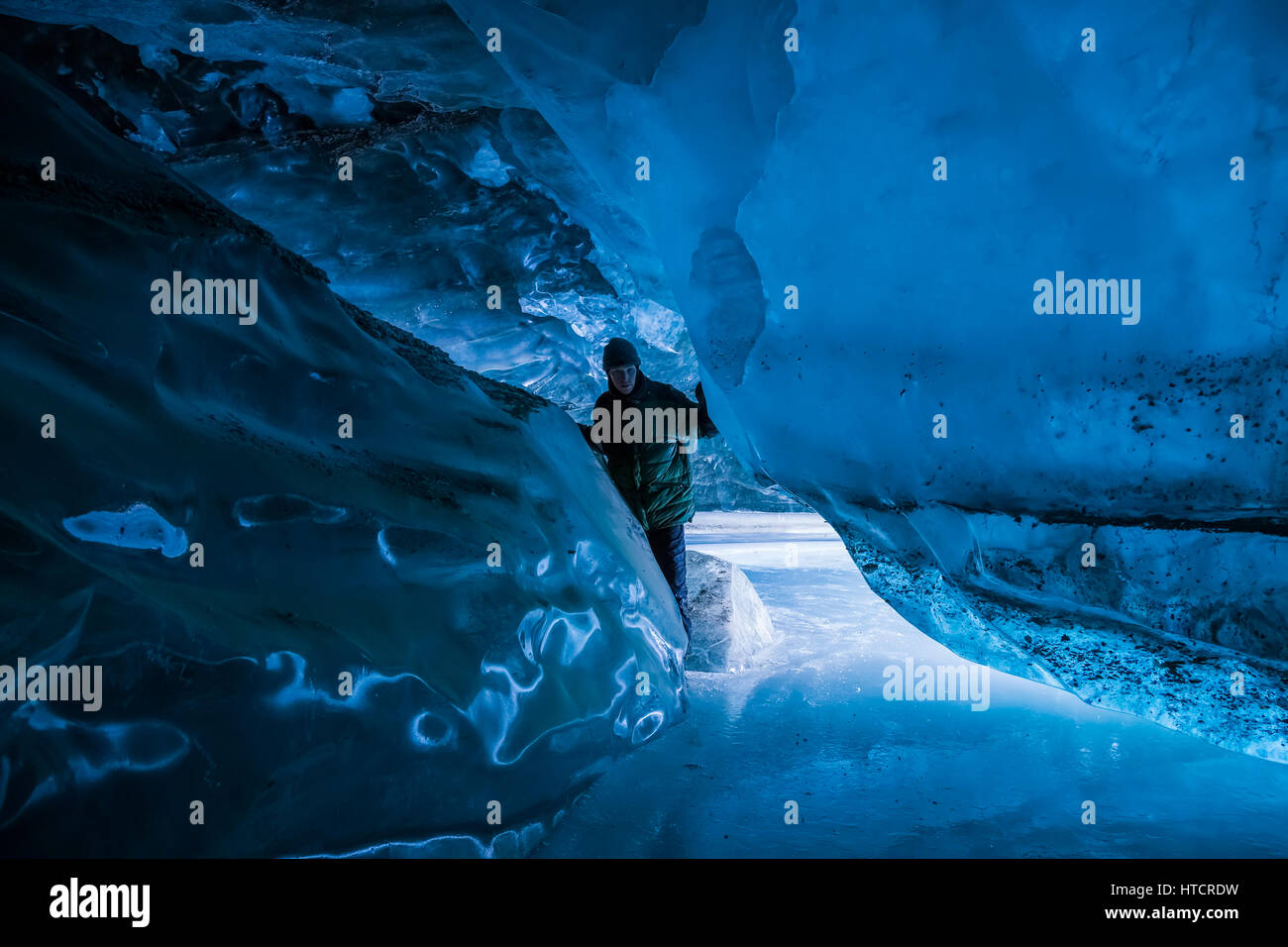 Un homme à l'intérieur d'un glacier Canwell caverne dans la chaîne de l'Alaska en hiver. Banque D'Images