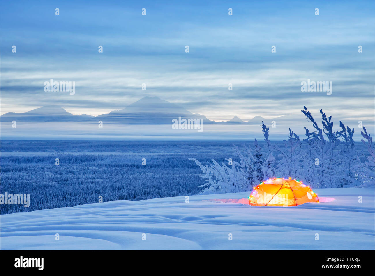 Un Mont Drum enneigé et la vallée de la rivière Copper au crépuscule avec Une tente décorée de lumières de Noël dans le Foreground, le sud de l'Alaska,... Banque D'Images