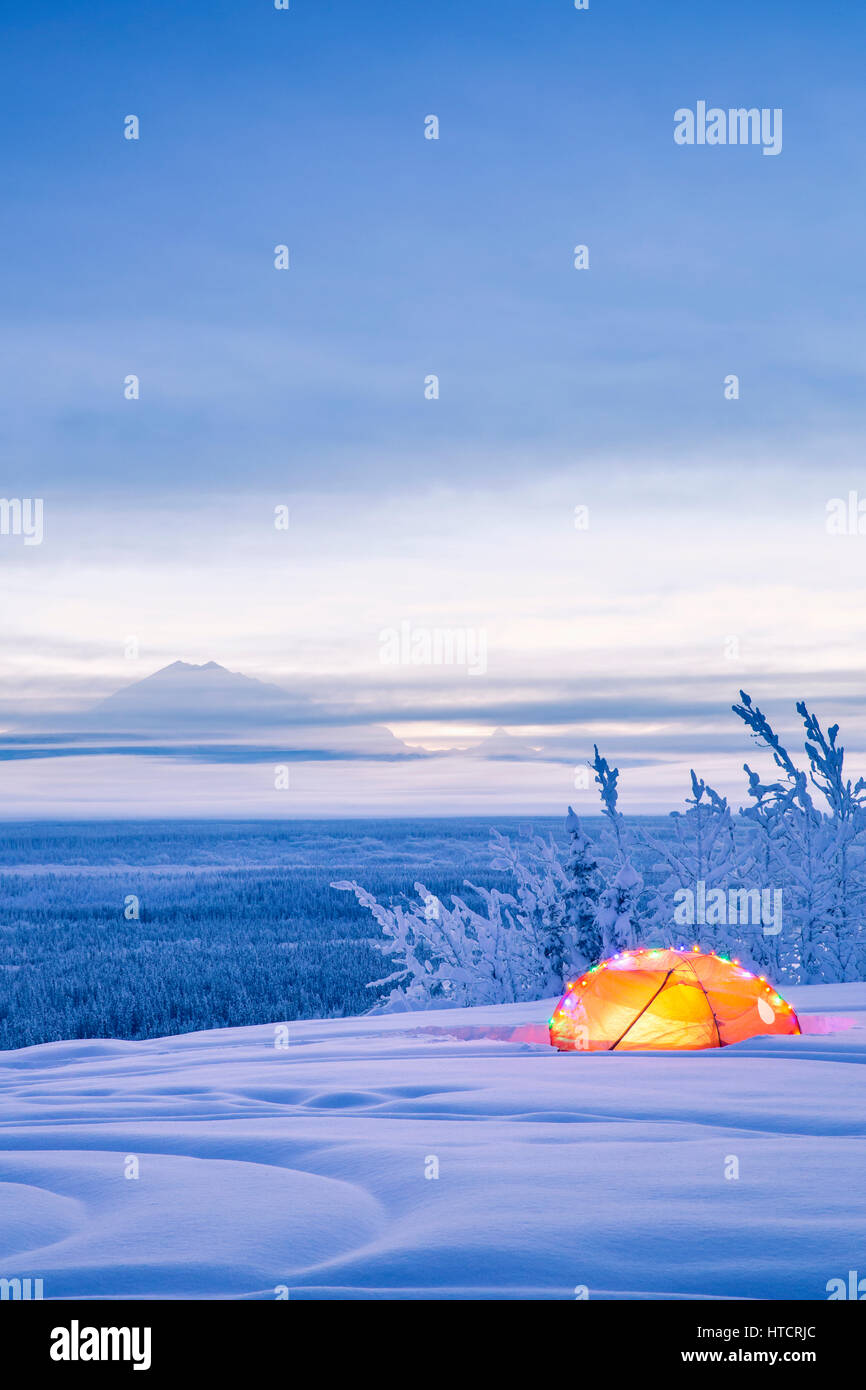 Un Mont Drum enneigé et la vallée de la rivière Copper au crépuscule avec Une tente décorée de lumières de Noël dans le Foreground, le sud de l'Alaska,... Banque D'Images