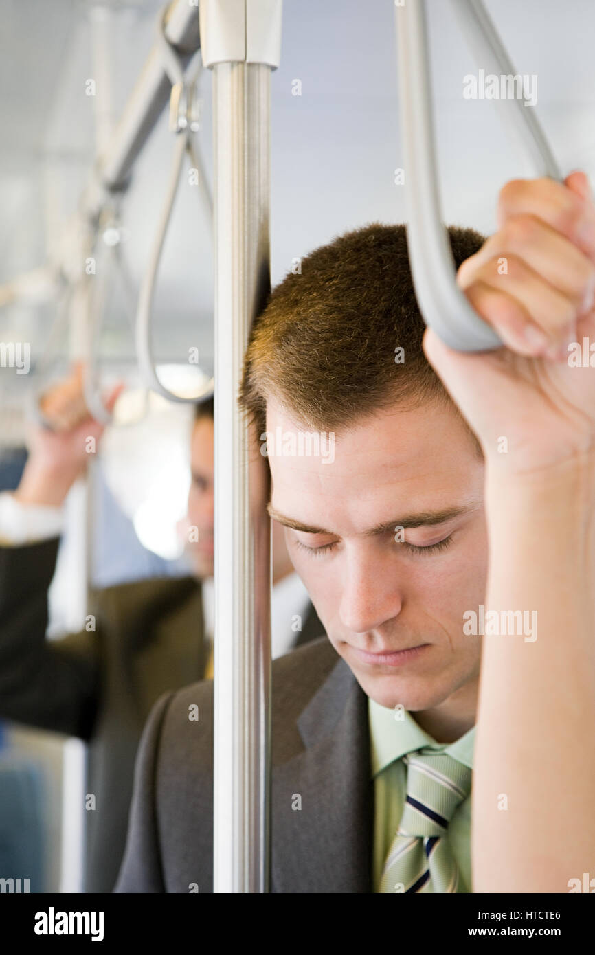 Businessman sleeping on train Banque D'Images