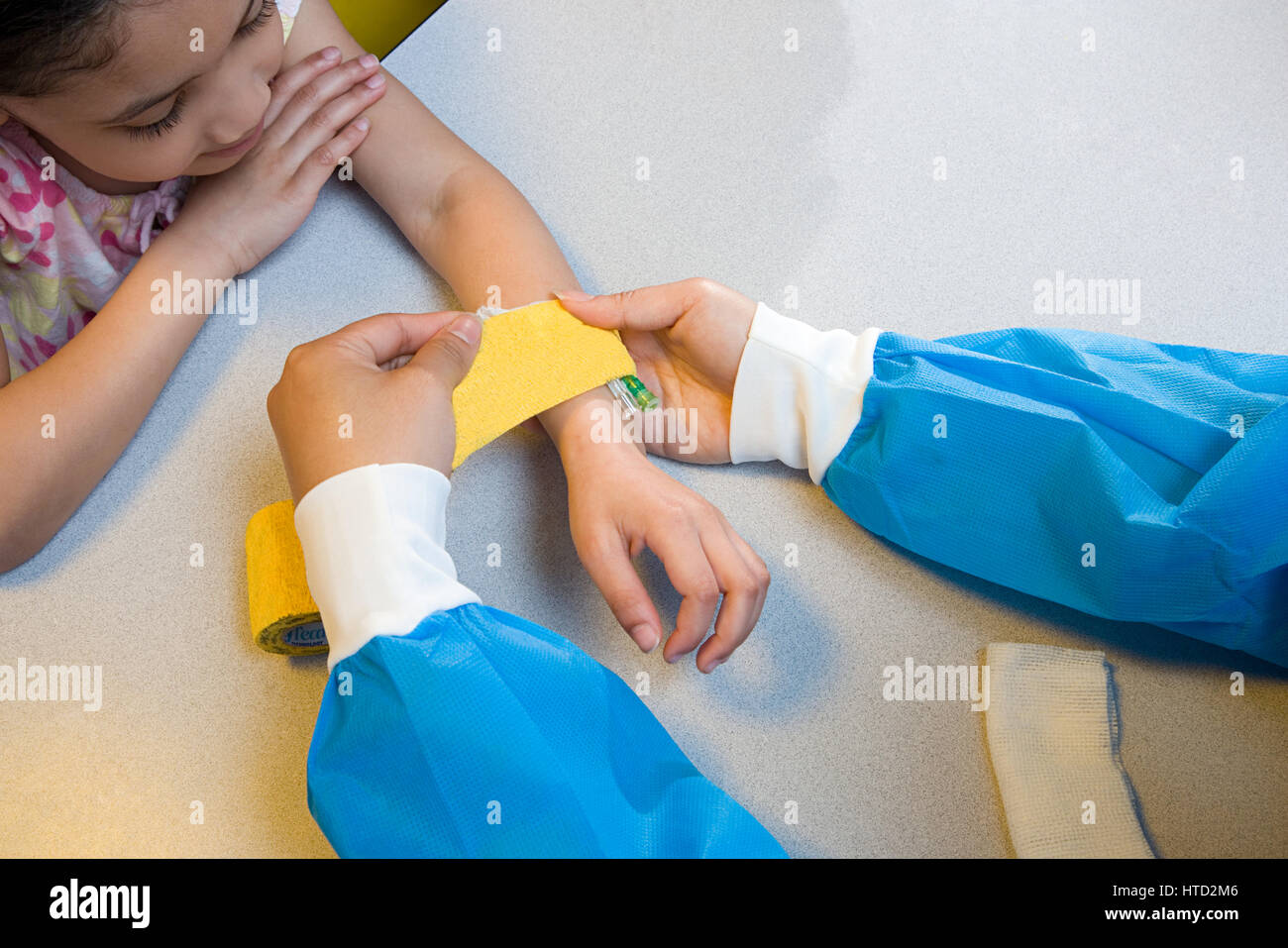 Girl infirmière mettre bandage sur son bras Banque D'Images
