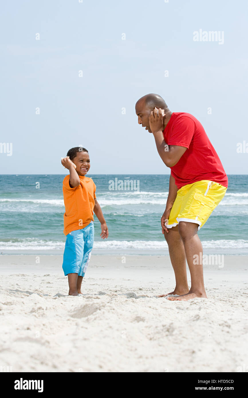 Père et fils holding shells Banque D'Images
